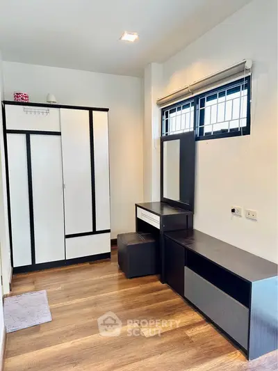 Modern bedroom with sleek furniture and wooden flooring