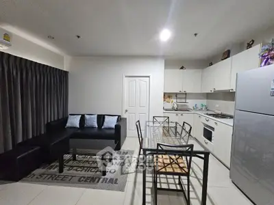 Modern open-layout kitchen and living room with sleek furniture and appliances.