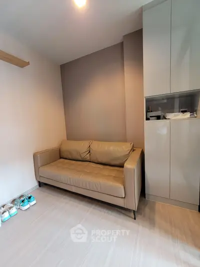Modern living room with sleek sofa and storage cabinet, perfect for urban living.
