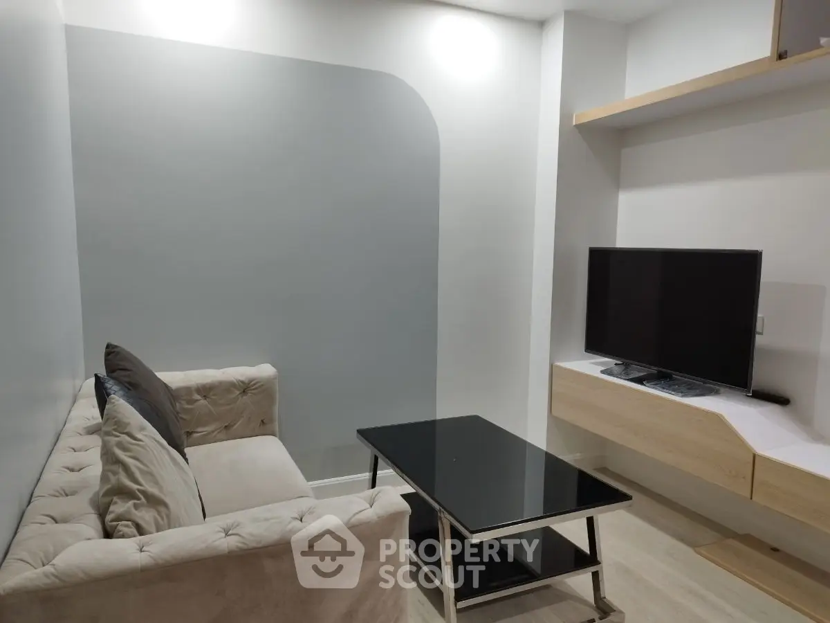 Modern living room with sleek TV setup and cozy sofa