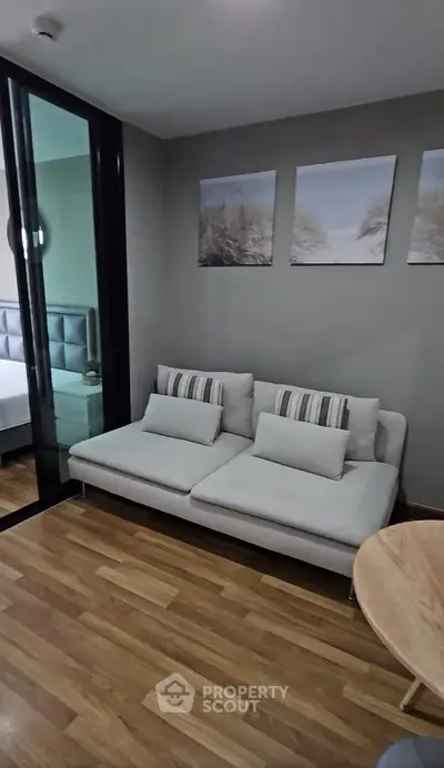 Modern living room with stylish sofa and wooden flooring, perfect for cozy relaxation.