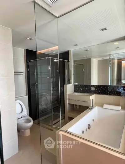 Luxurious modern bathroom with glass shower and bathtub in upscale apartment.