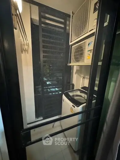 Compact laundry area with washing machine and air conditioning units in modern apartment.