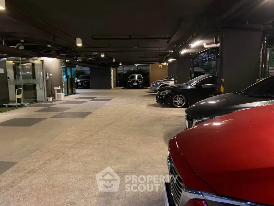 Spacious underground parking area with multiple cars and ample lighting.