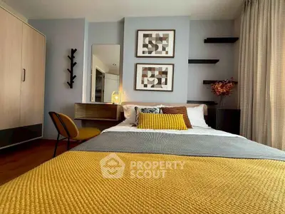 Stylish bedroom with modern decor, cozy bedding, and elegant wall art in a well-lit space.