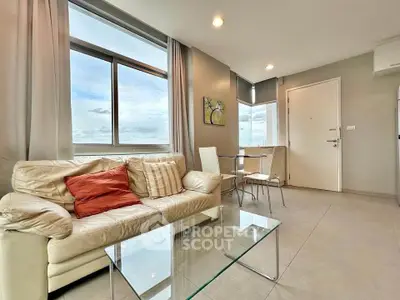 Modern living room with large windows and stylish furniture in a high-rise apartment.