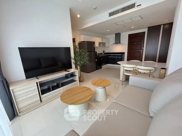Modern open-plan living room with sleek kitchen and stylish furniture in a contemporary apartment.