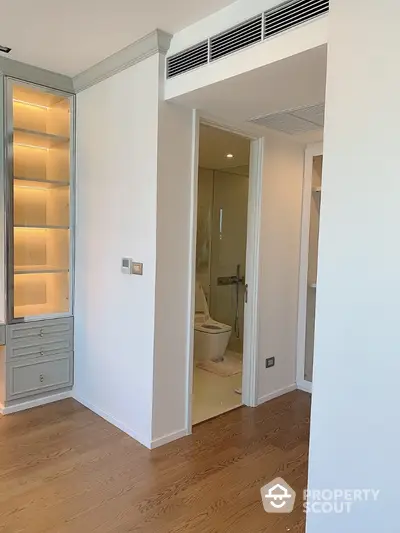 Modern apartment interior with wooden flooring and built-in shelving