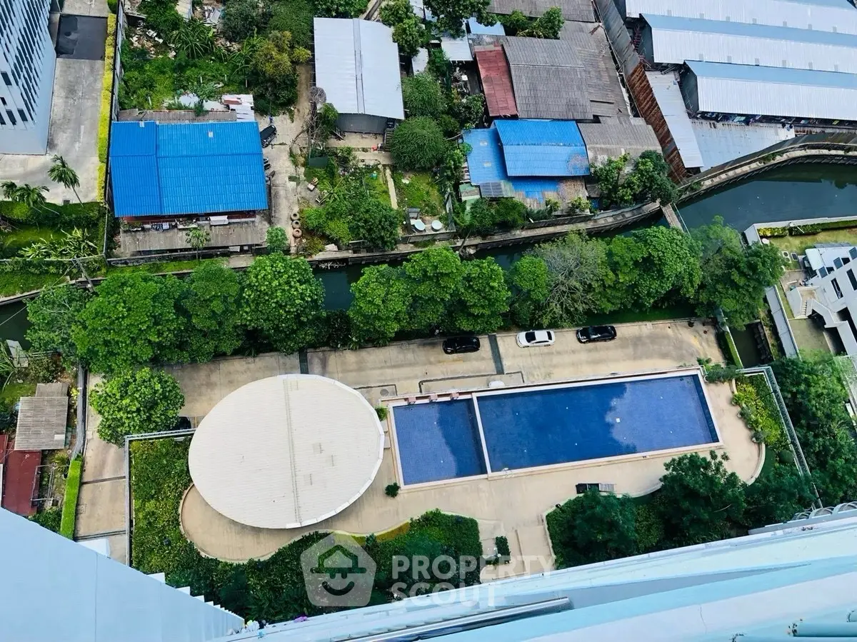 Stunning aerial view of residential pool and lush greenery in urban setting, perfect for relaxation and leisure.