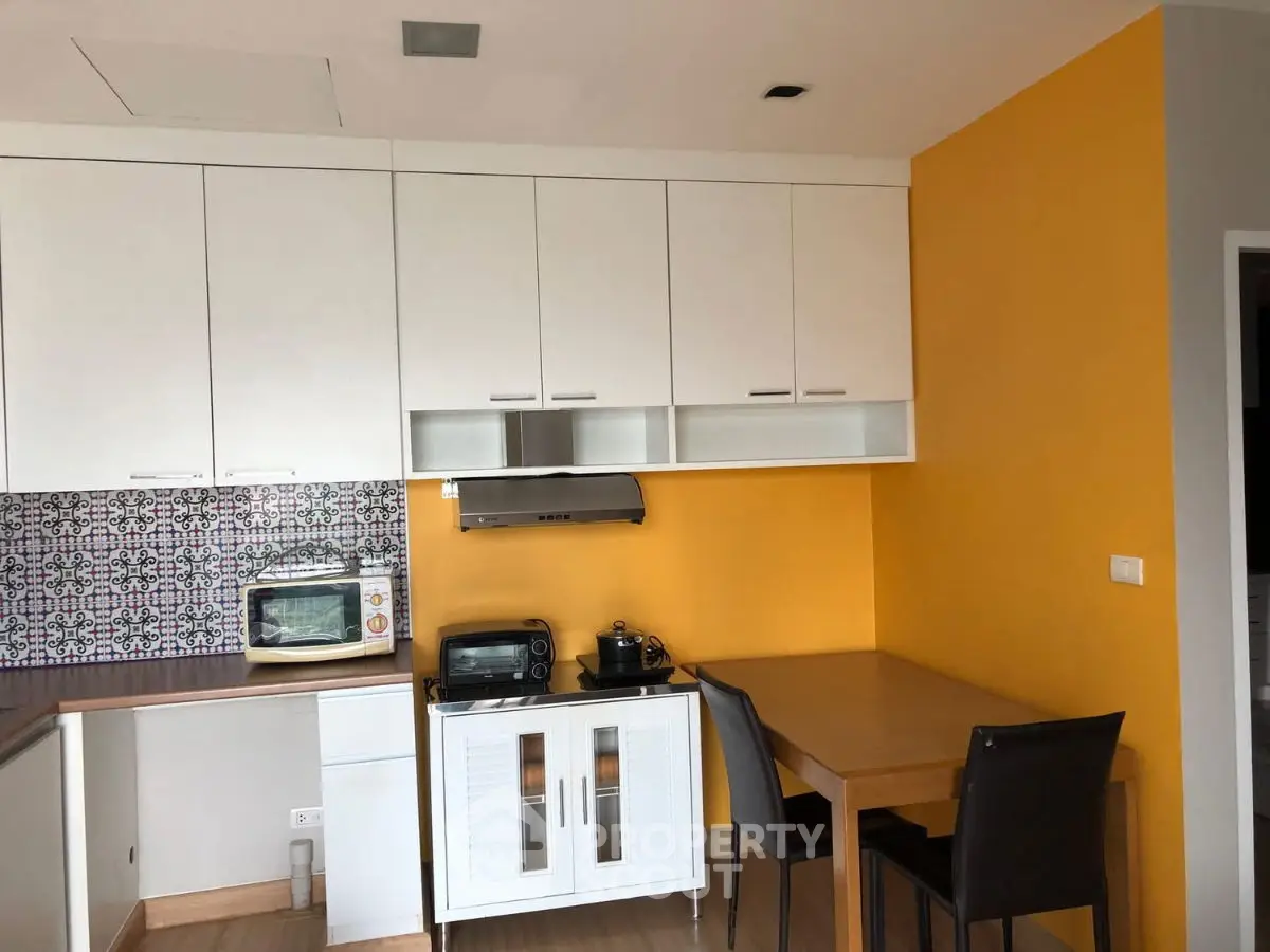 Charming kitchen with vibrant yellow accent wall and modern appliances