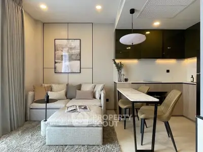 Modern living room with cozy seating and sleek kitchen in open layout apartment.