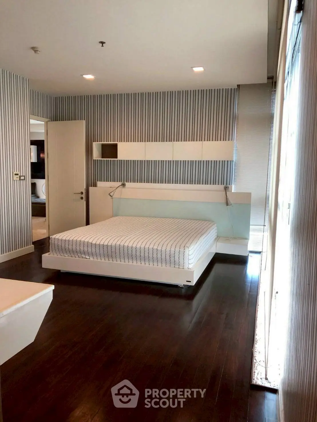 Spacious modern bedroom with sleek design and hardwood floors