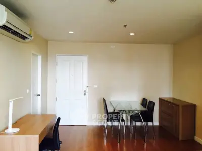 Modern apartment interior with dining area and workspace, featuring wooden flooring and minimalist design.