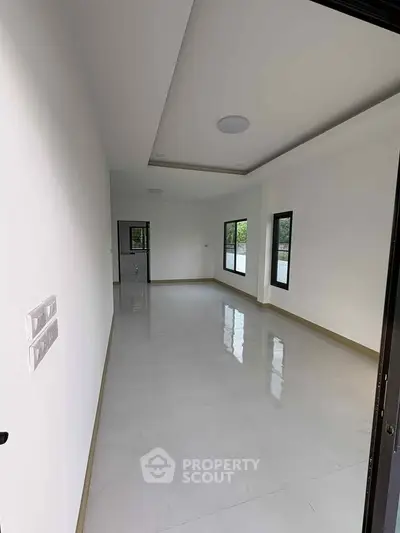 Spacious empty room with large windows and glossy floor, ideal for customization.