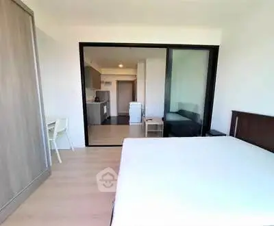 Modern bedroom with open layout and kitchen view in a stylish apartment.