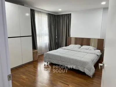 Spacious bedroom with modern decor and wooden flooring