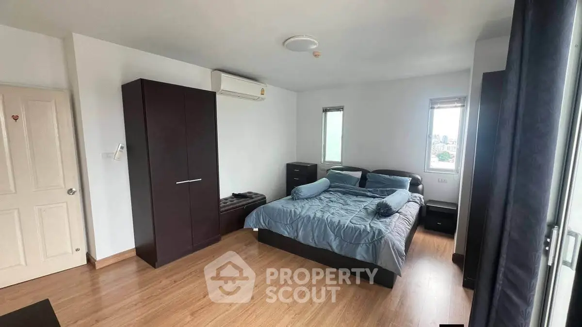 Spacious bedroom with modern furnishings and natural light in a stylish apartment.