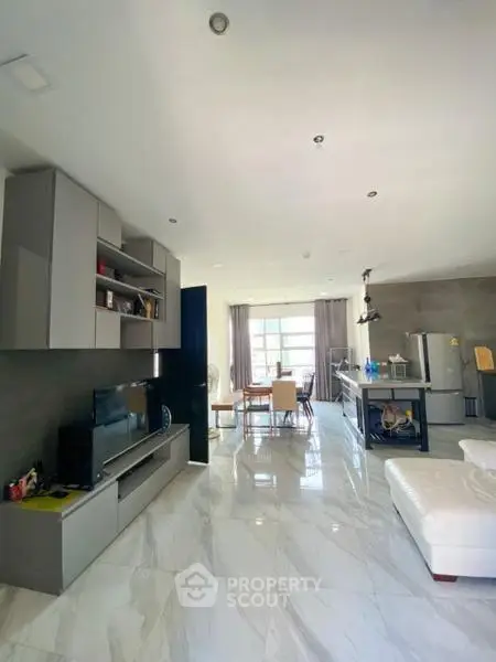 Spacious modern living room with open kitchen and elegant marble flooring