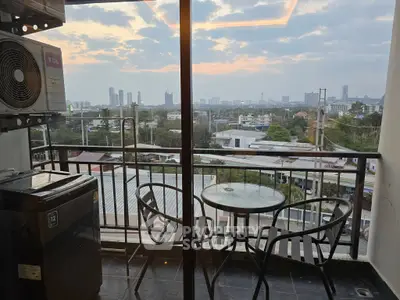 Stunning balcony view with city skyline and cozy seating area at sunset