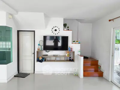 Modern living room with wall-mounted TV and stylish staircase