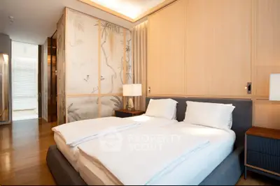 Luxurious bedroom with elegant decor and soft lighting, featuring a comfortable bed and stylish wooden accents.