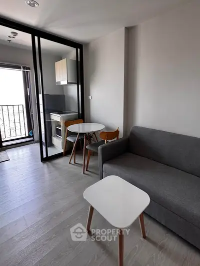 Modern apartment with open layout, featuring cozy living area and compact kitchen.