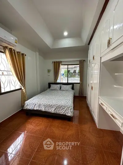 Spacious bedroom with large window and built-in wardrobe in modern home.