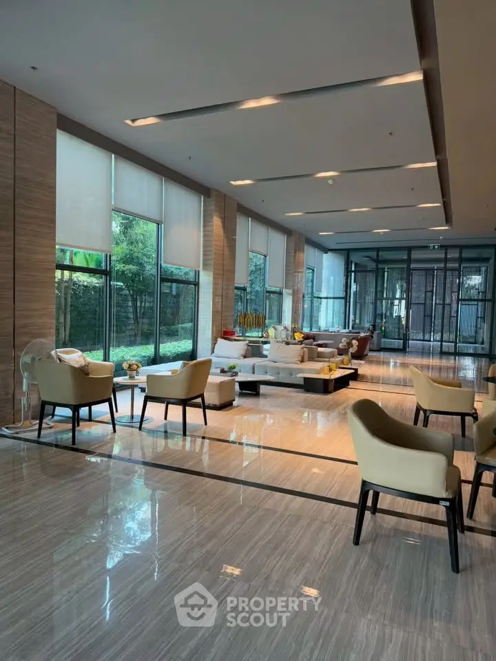 Luxurious lobby with elegant seating and large windows offering garden views, perfect for relaxation and social gatherings.