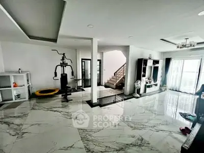 Spacious modern living room with marble flooring and home gym equipment
