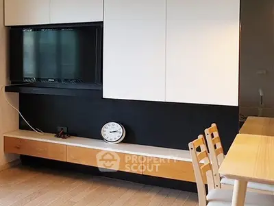Modern living room with sleek TV setup and stylish dining area