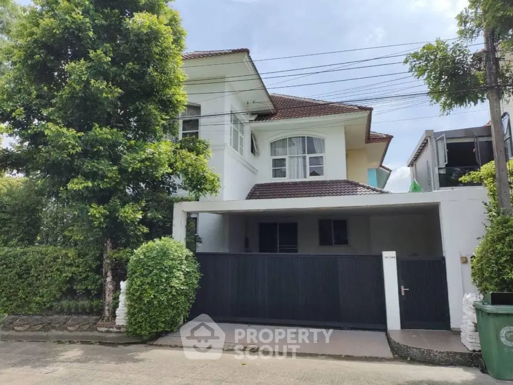 Charming two-story house with lush greenery and modern design in a serene neighborhood.