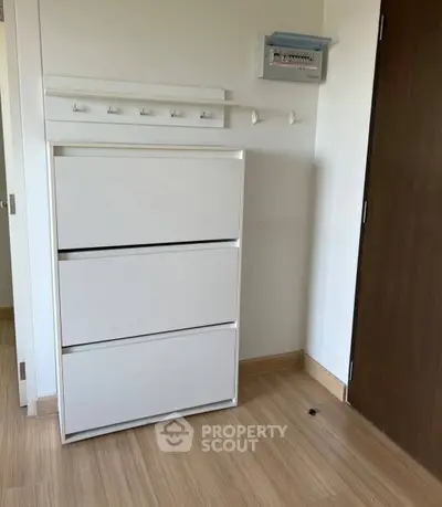 Modern interior with sleek white storage unit and wooden flooring, perfect for organized living.