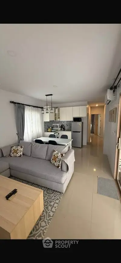 Modern open-plan living room with stylish kitchen and cozy seating area, perfect for entertaining.