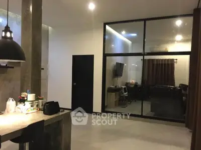 Modern open-plan living area with sleek design and glass partition