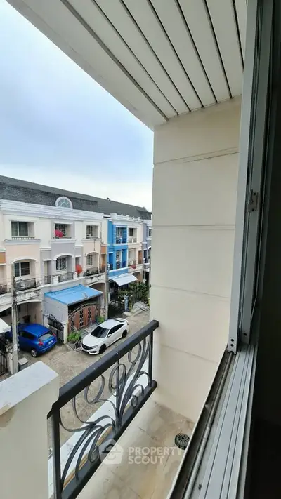 Charming balcony view overlooking colorful townhouses in a serene neighborhood.