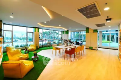 Spacious modern living room with vibrant decor and stunning city view.