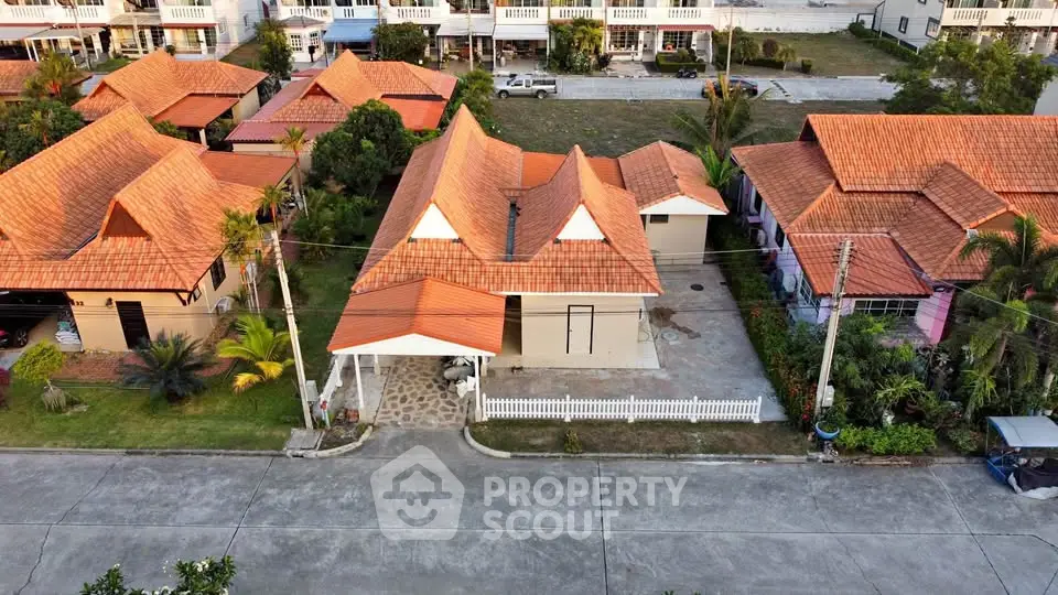 Charming suburban homes with red-tiled roofs and lush greenery in a peaceful neighborhood.