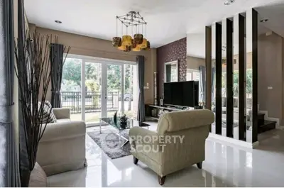 Elegant living room with modern decor and large windows offering garden views.