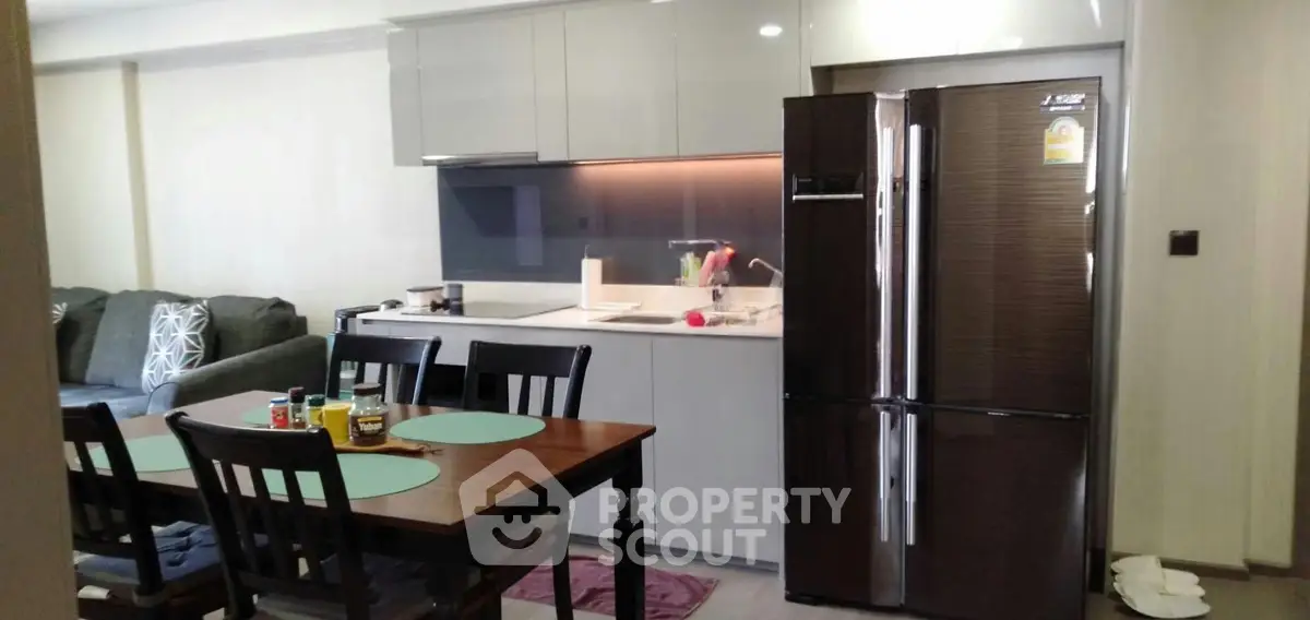 Modern kitchen with sleek cabinetry and spacious dining area in a stylish apartment.