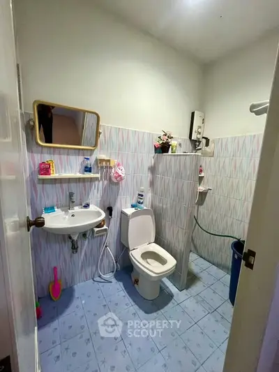 Charming bathroom with modern fixtures and colorful tile flooring, perfect for a cozy home.