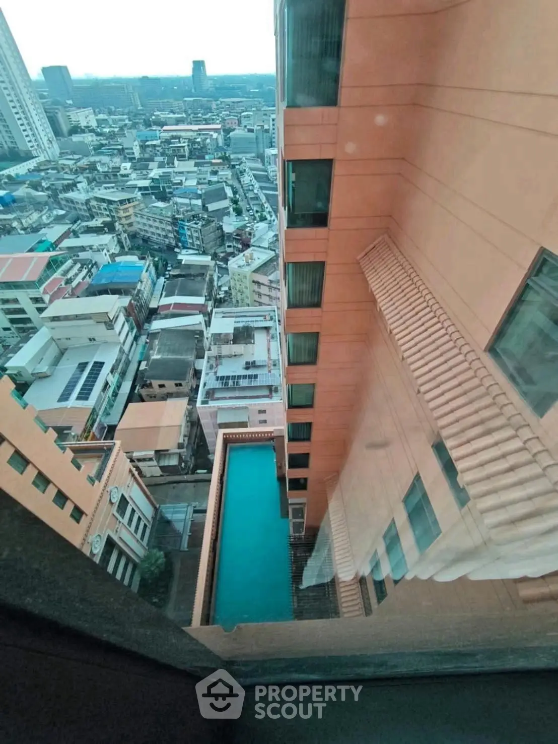 Stunning high-rise view with rooftop pool overlooking cityscape