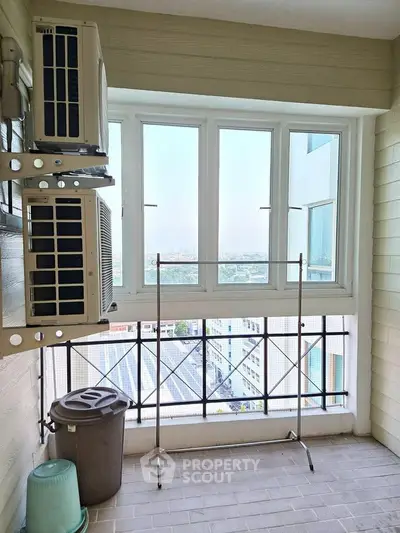 Bright balcony with city view and air conditioning units, perfect for relaxation.