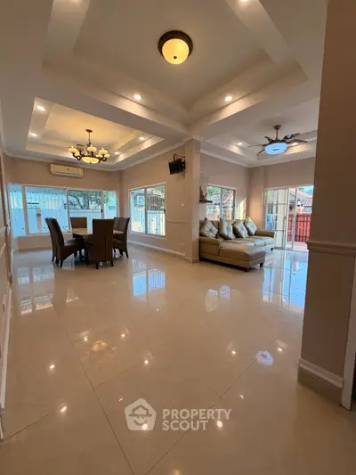 Spacious living room with elegant dining area and large windows for natural light.