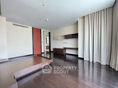Spacious modern living room with wooden flooring and large windows.