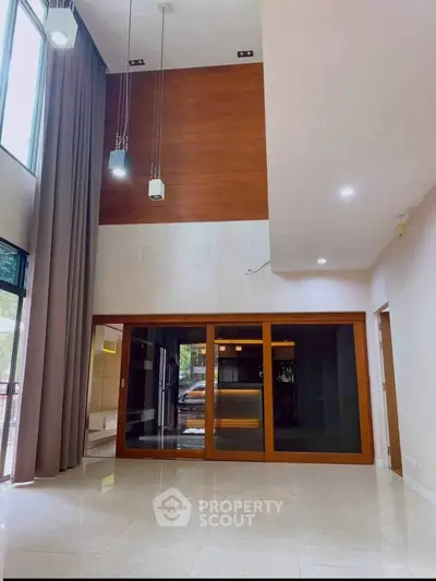 Spacious modern living room with high ceilings and large windows for natural light.