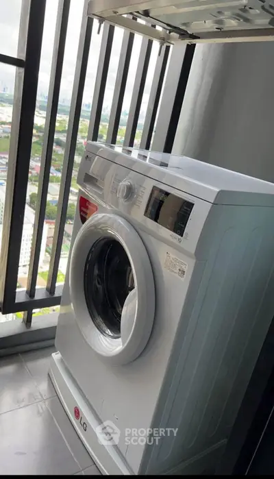 Modern washing machine on high-rise balcony with city view