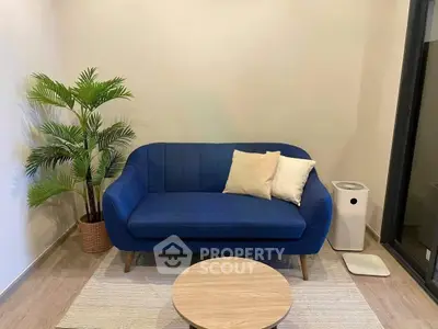 Chic living room with blue sofa, stylish decor, and modern air purifier.