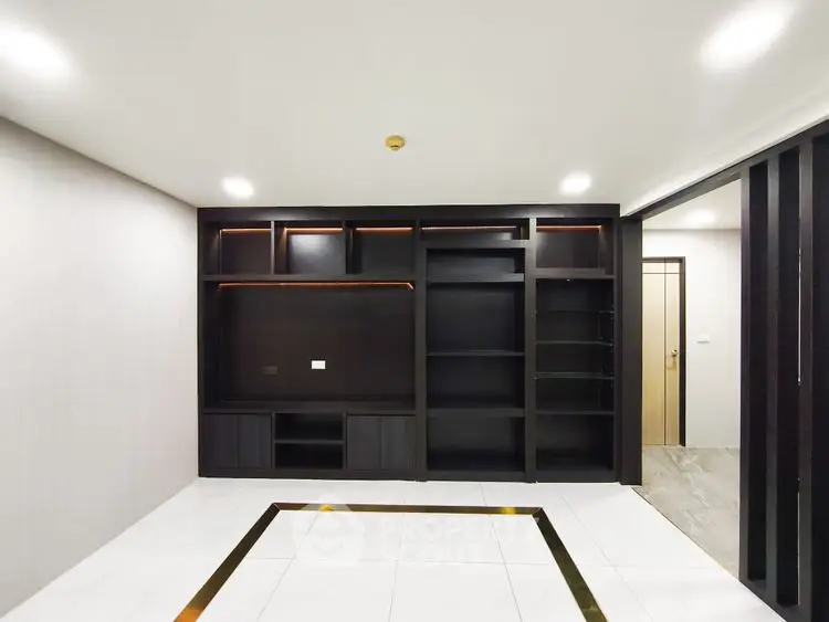 Spacious modern living room with sleek built-in shelving and elegant tile flooring