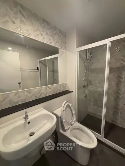 Modern bathroom with sleek fixtures and glass shower enclosure