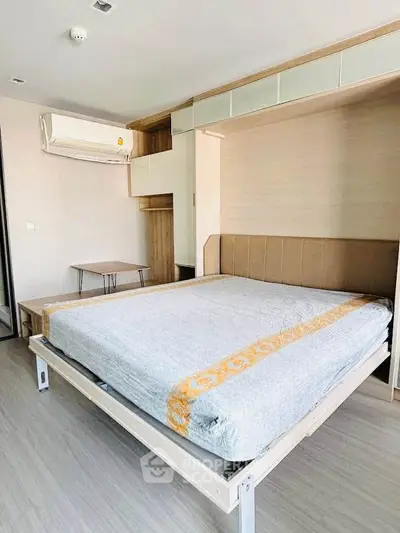 Modern bedroom with built-in storage and air conditioning in a stylish apartment.